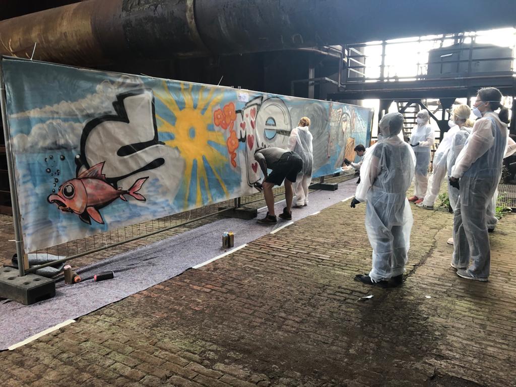 Personen bemalen Graffiti Wand in Schutzanzügen