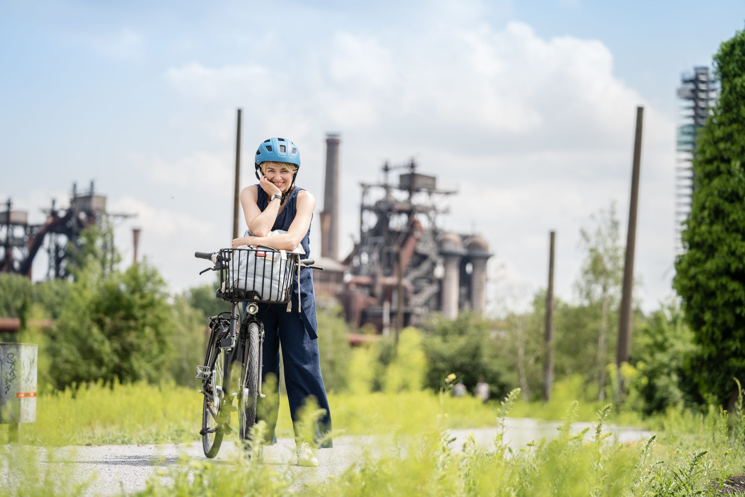 Frau mit Fahrrad vor dem Landschaftspark am Ende des Ruhrtalradwegs